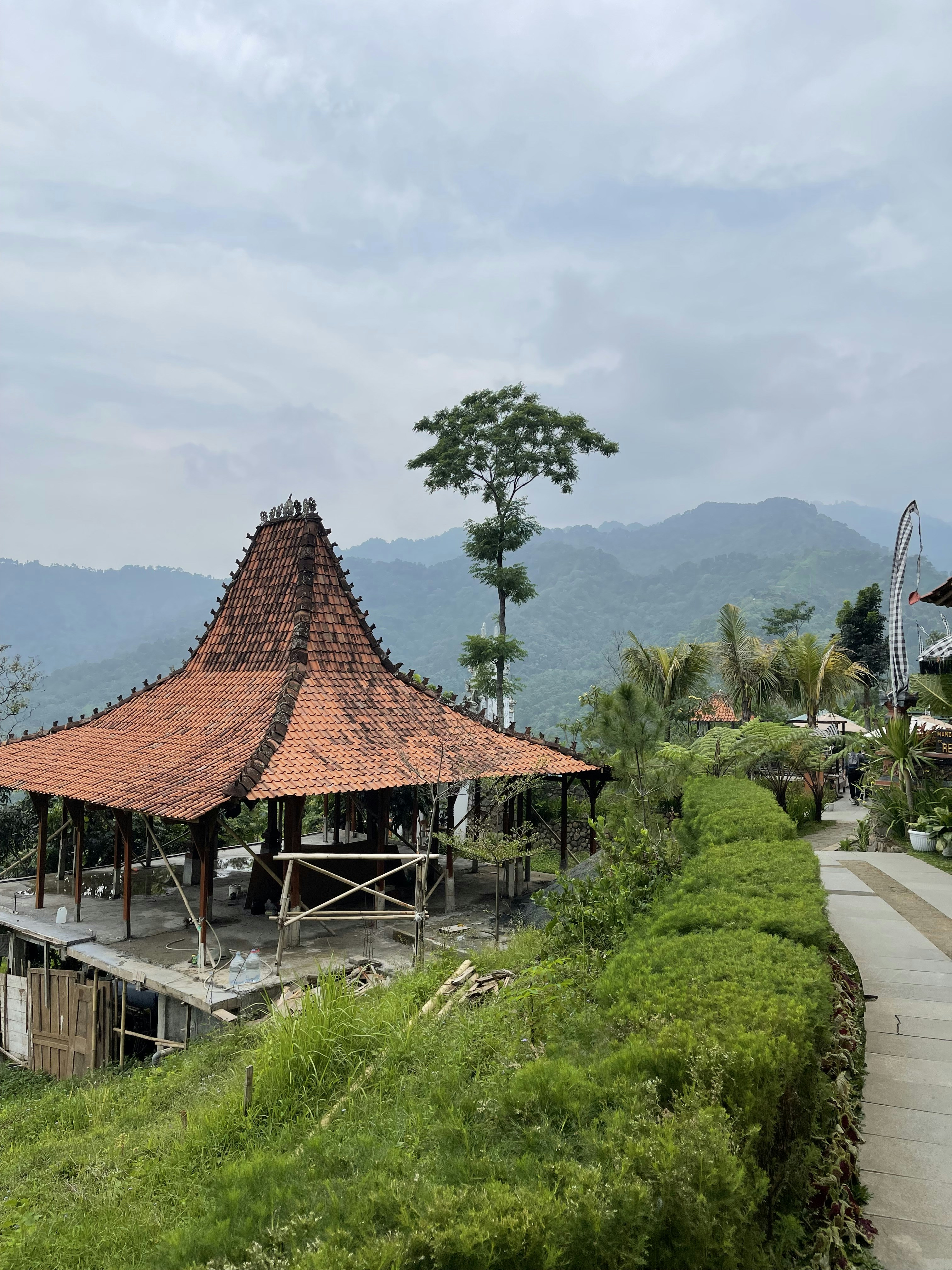 a wooden structure sitting on top of a lush green hillside