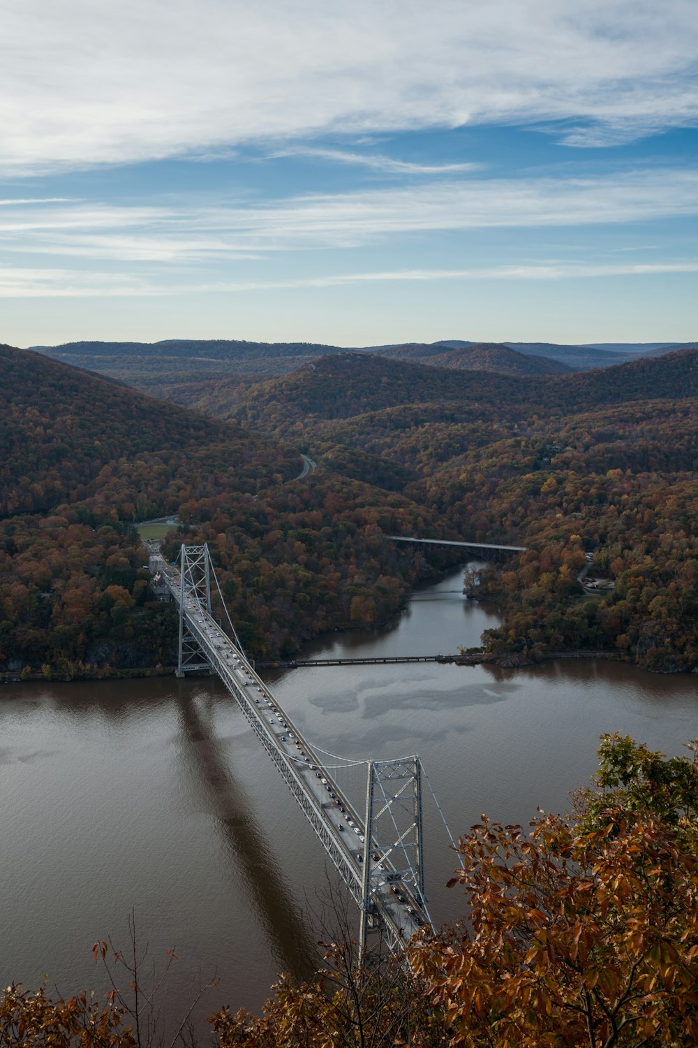 a bridge over a river surrounded by mountains