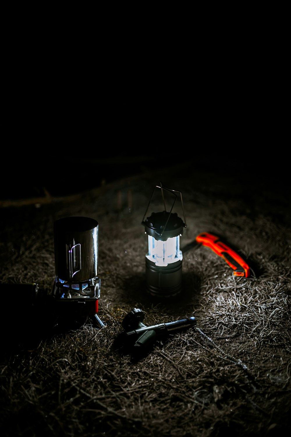 a lantern and some tools on the ground