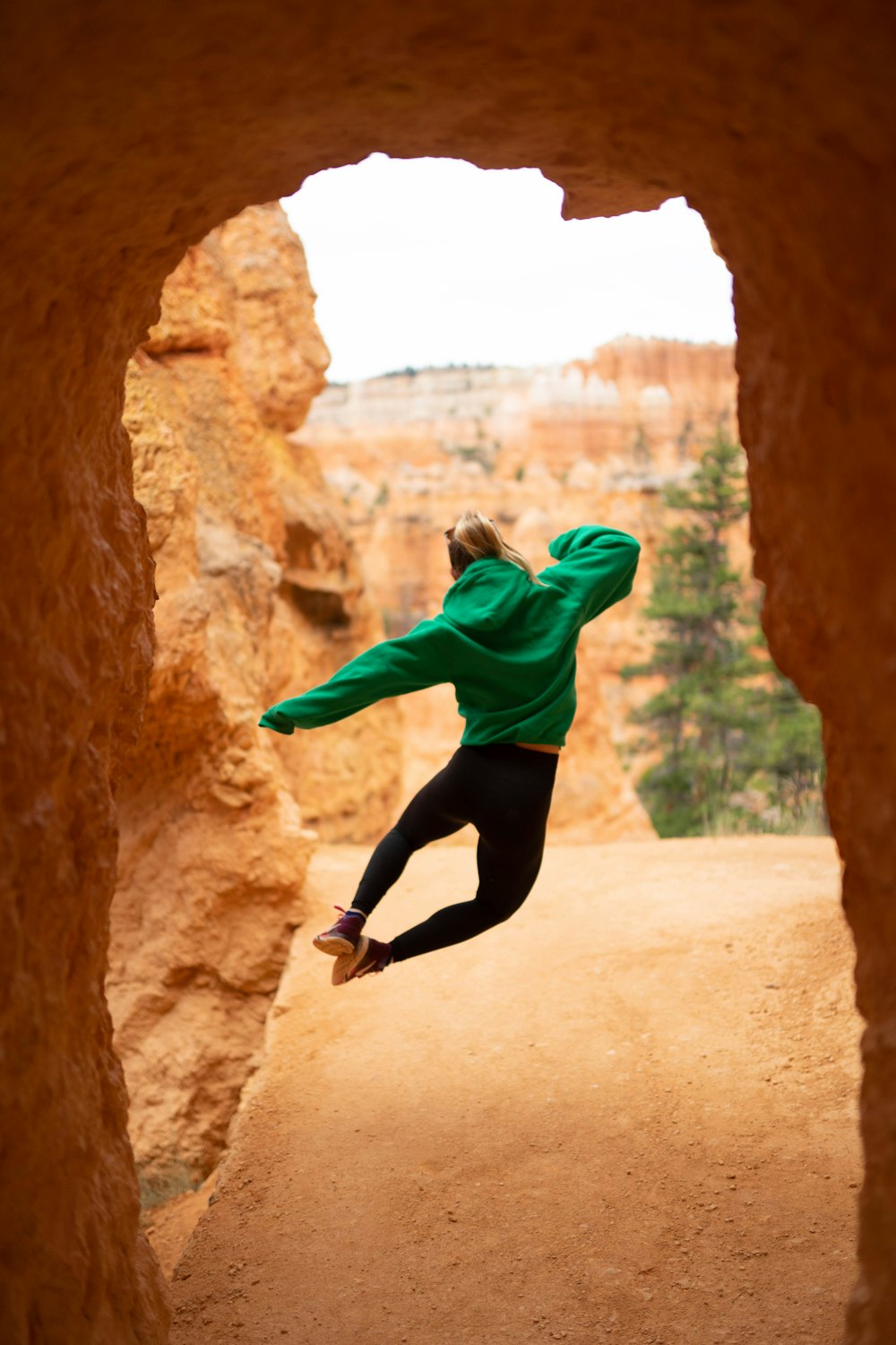 a person jumping in the air from a rock formation