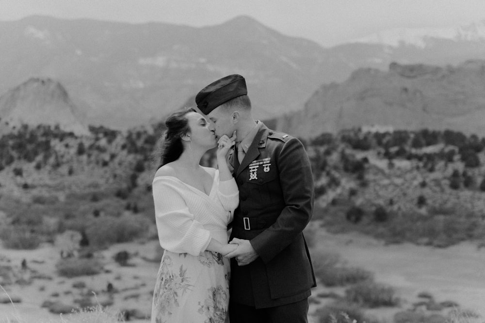 a man in a military uniform kissing a woman in a dress