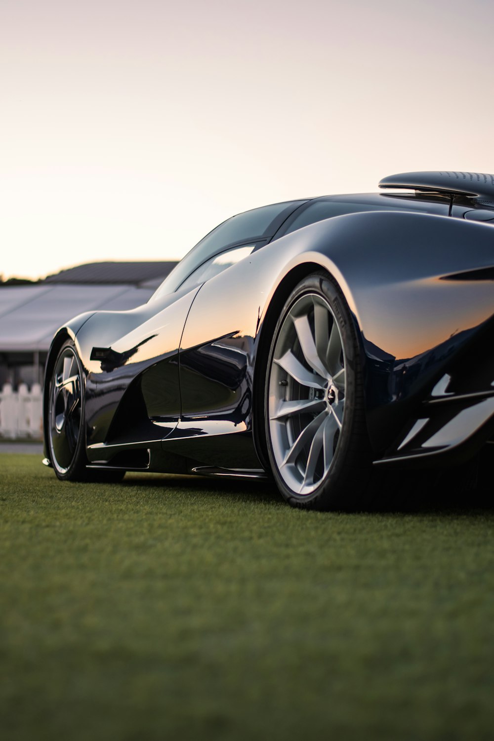 a black sports car parked on top of a lush green field