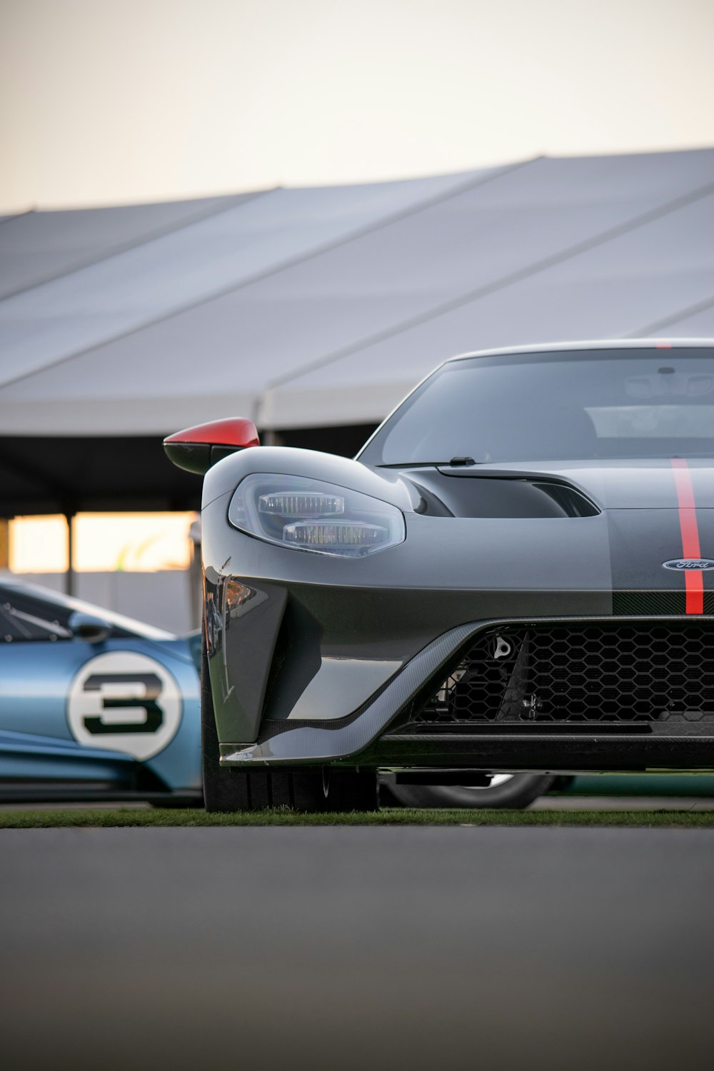 a grey sports car parked next to a blue sports car