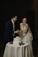 a man and woman cutting a wedding cake