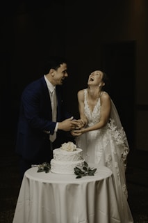 A joyful moment captured of a couple cutting their wedding cake.