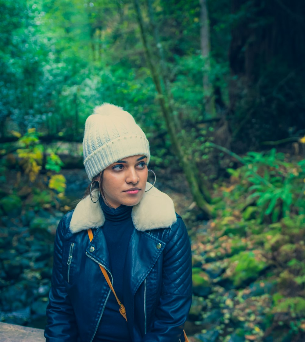 a woman wearing a blue jacket and a white hat