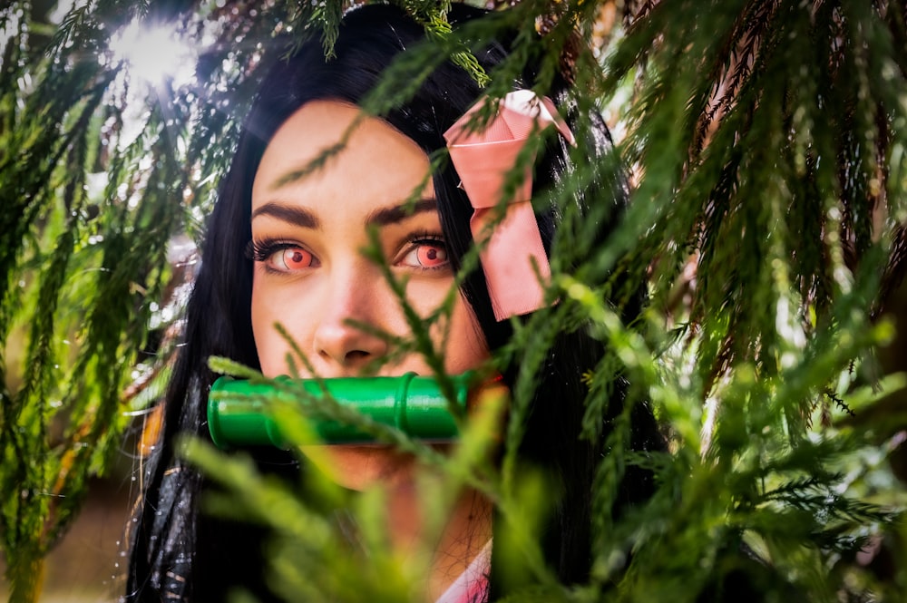 a woman holding a green tube in front of her face