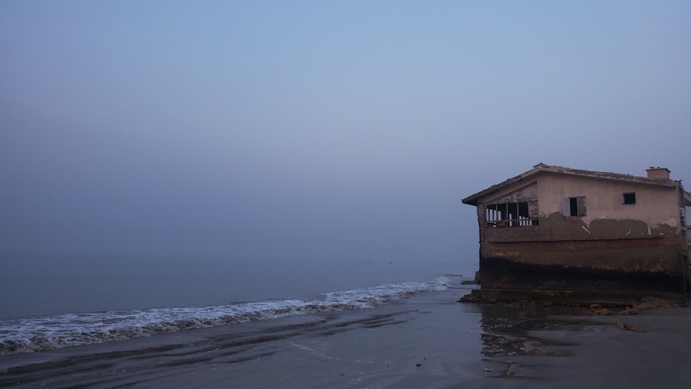 a house sitting on top of a beach next to the ocean