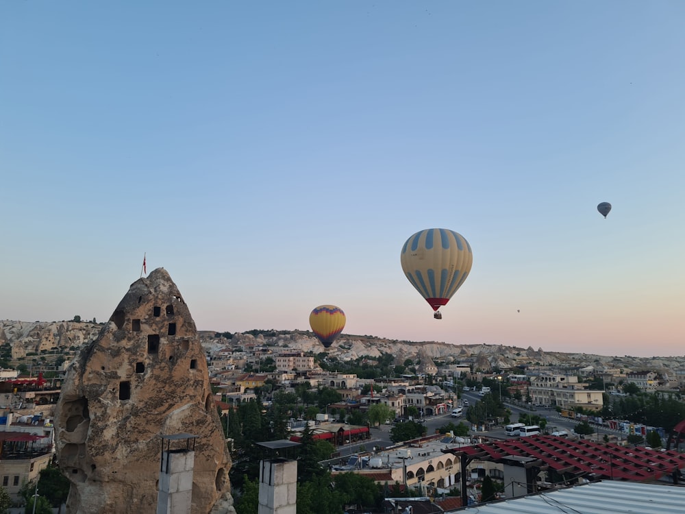 a couple of hot air balloons flying over a city