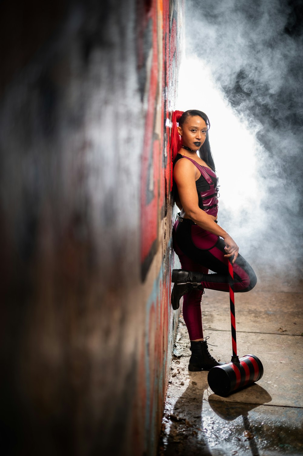 a woman leaning against a wall with a cane