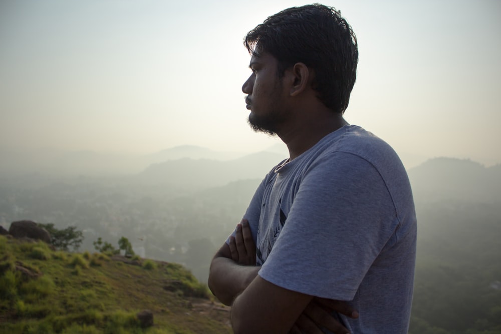 a man standing on top of a lush green hillside