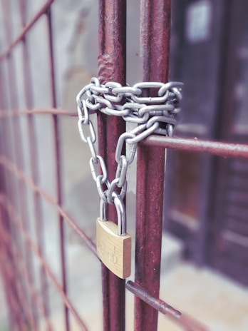 a padlock attached to a gate with a chain