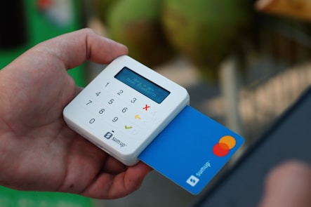 a person holding a credit card and a cell phone