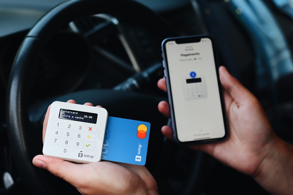 a person holding a credit card and a mobile phone