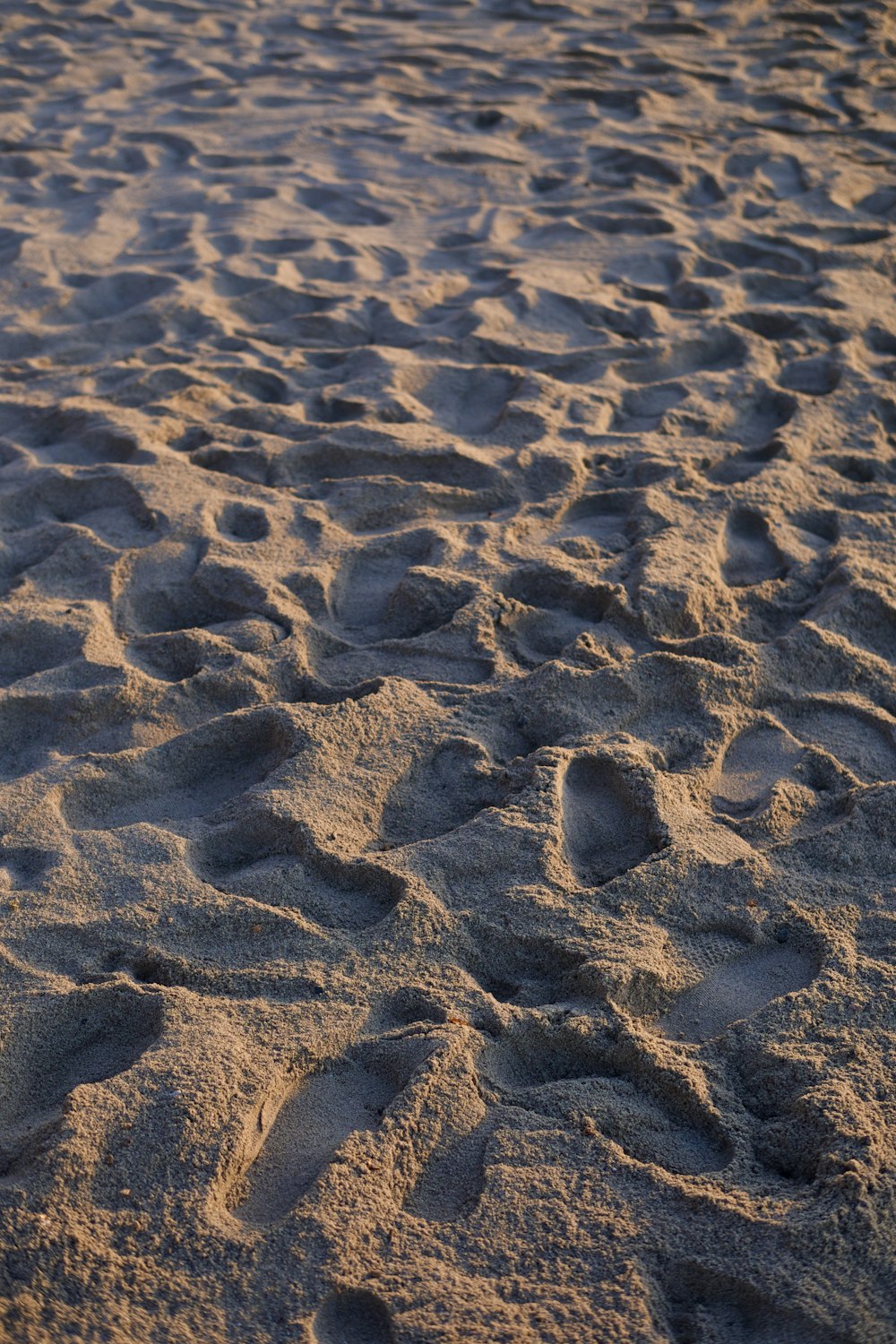 a close up of sand with footprints on it