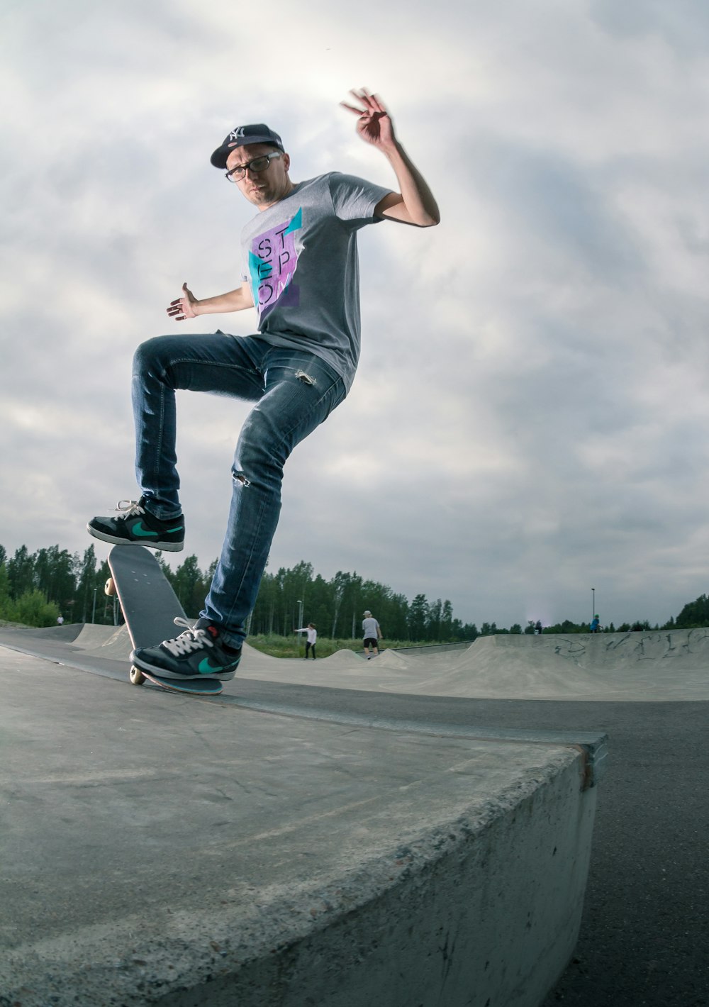 a man riding a skateboard up the side of a cement ramp