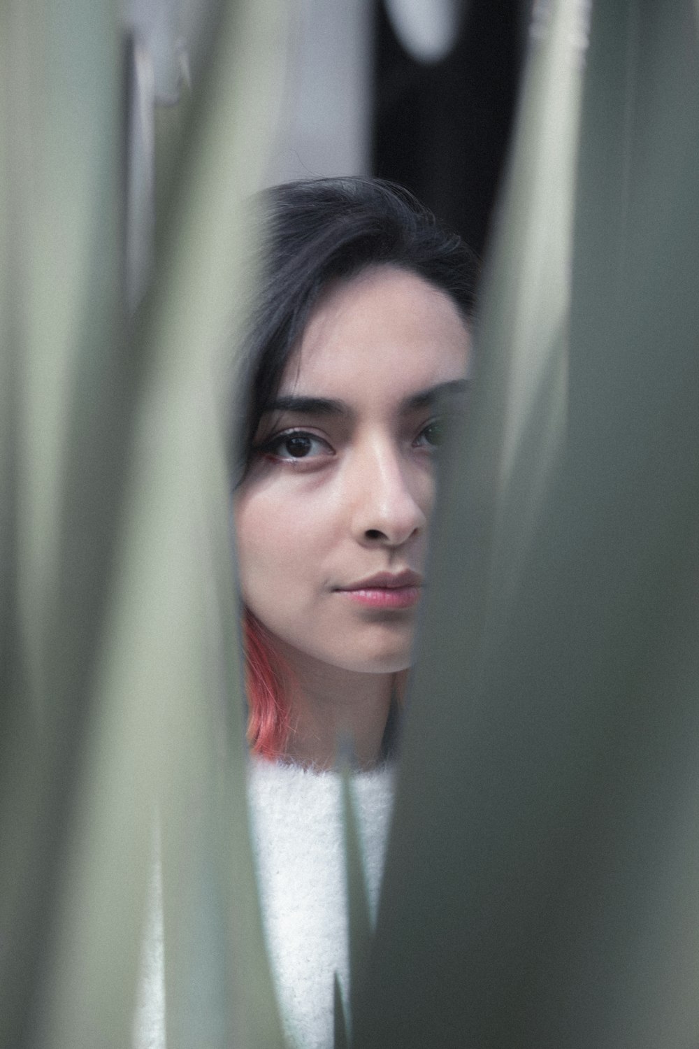 a woman with red hair looking out of a window