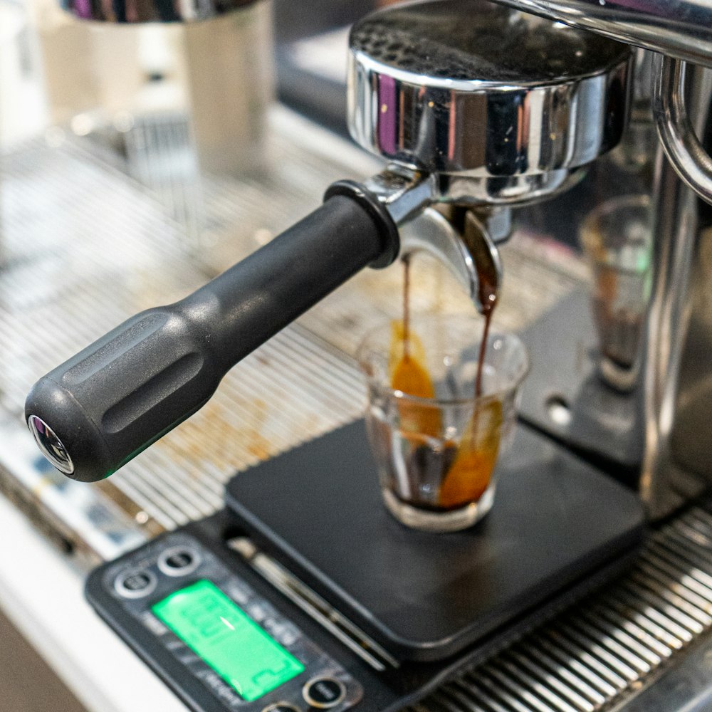 uma máquina de café expresso que faz uma xícara de café