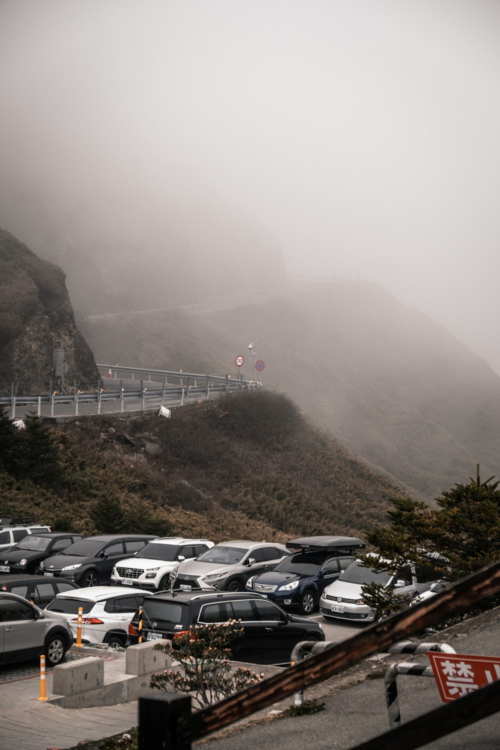 a parking lot filled with lots of cars on a foggy day