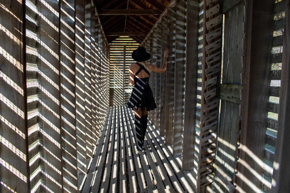 a woman in a black and white dress standing in a tunnel