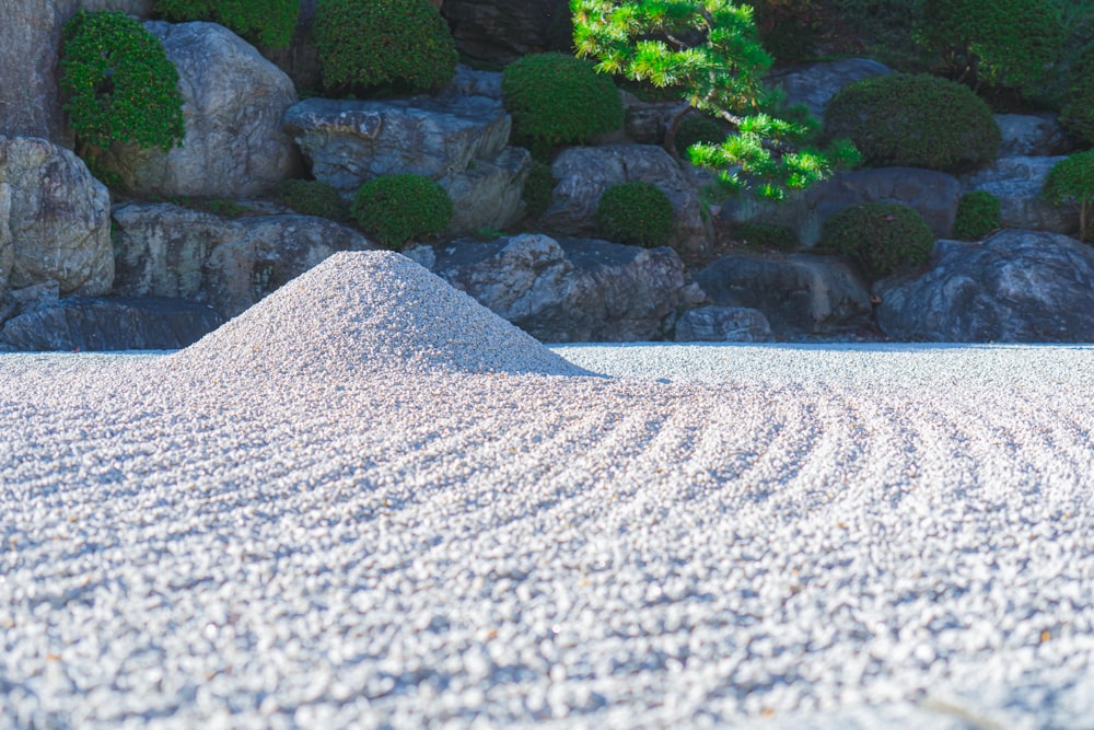 a pile of sand sitting in front of a rock wall
