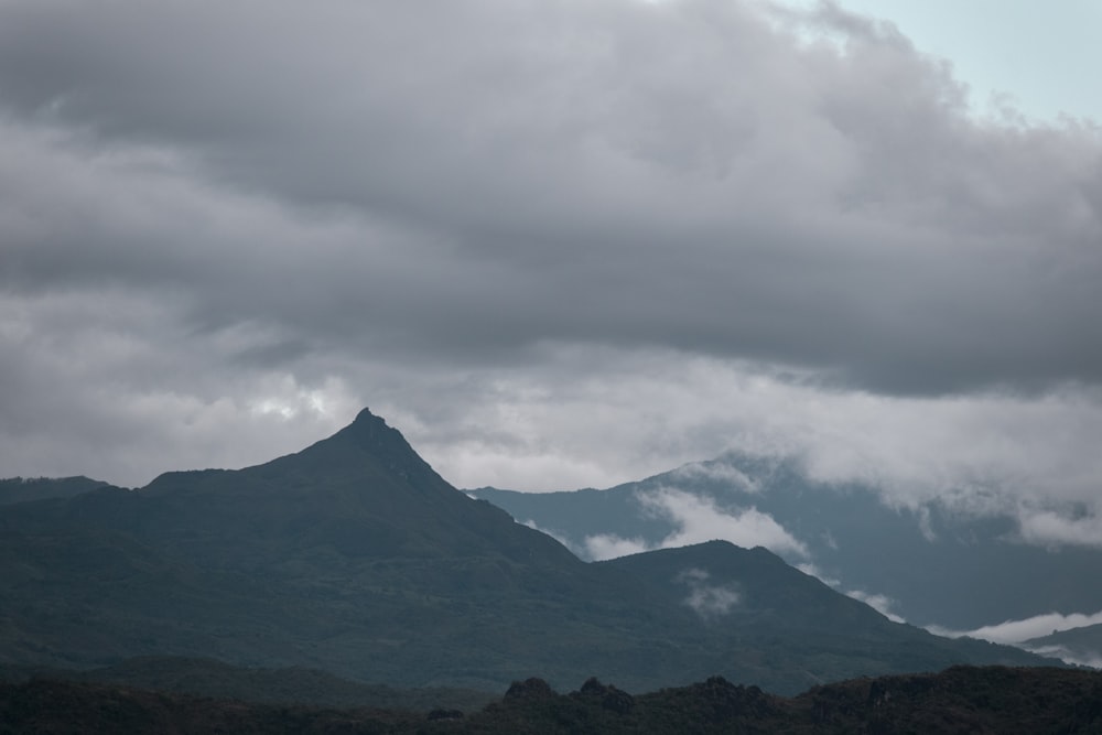 a mountain range with clouds in the sky