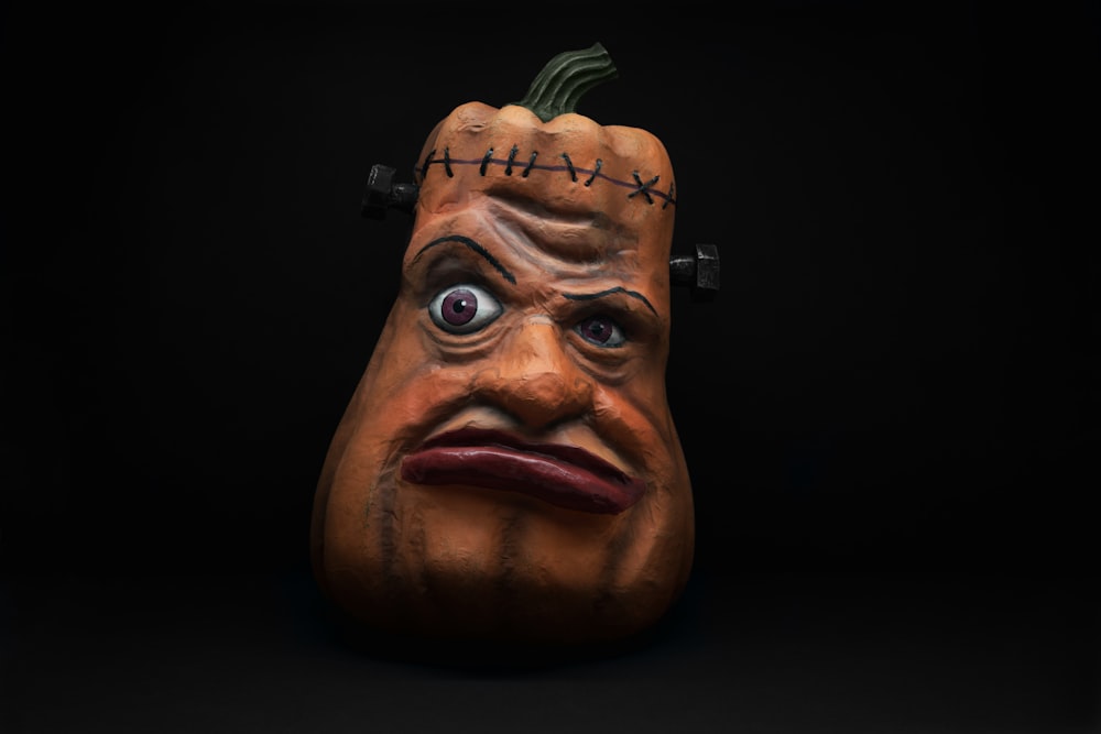 a close up of a pumpkin mask on a black background