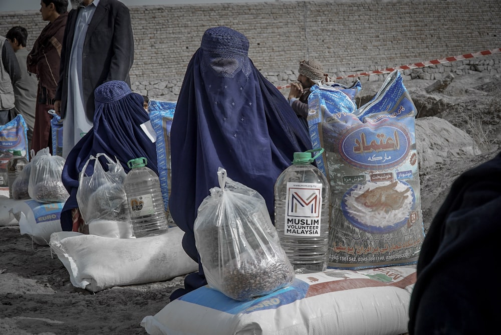 a group of people standing next to bags of sand