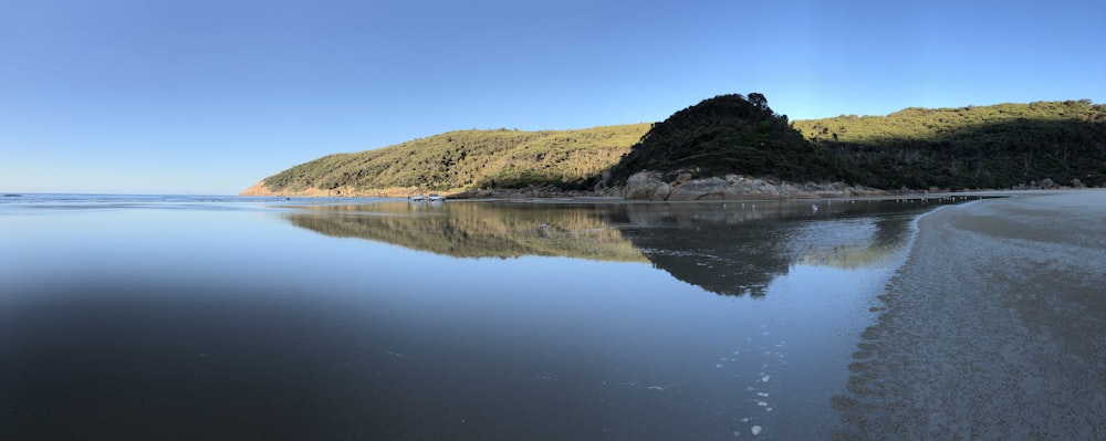 a body of water with a mountain in the background