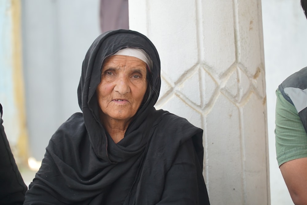 a woman in a black shawl sitting next to a man