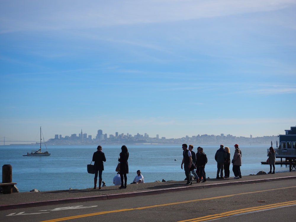 a group of people standing on the side of a road