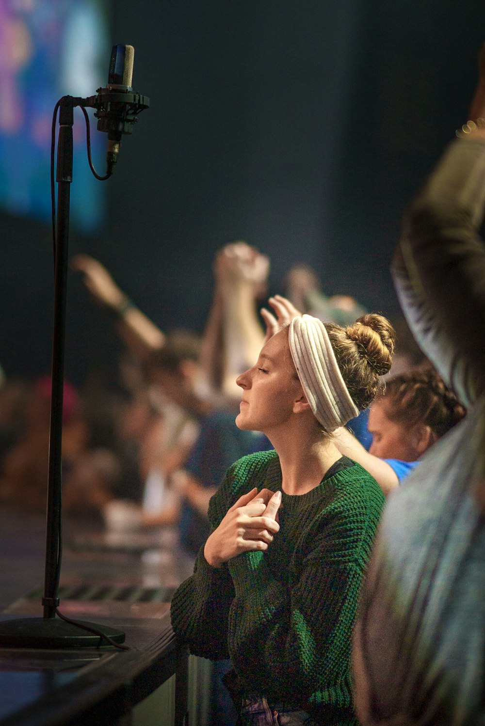 a woman in a green top is standing in front of a microphone