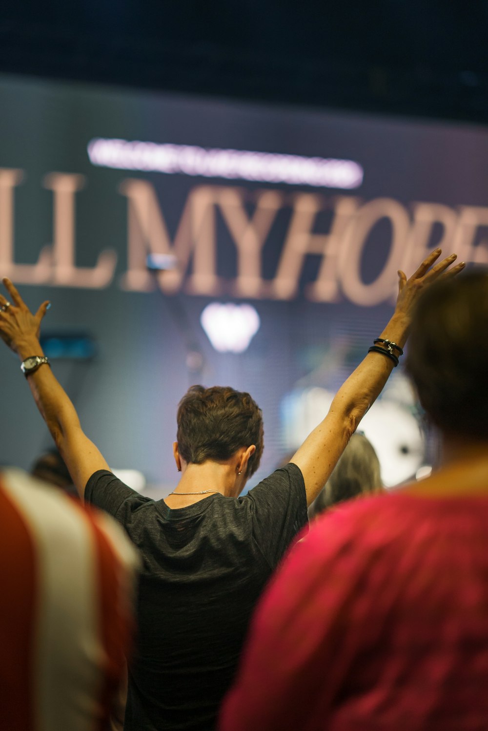 a man standing in front of a sign with his hands in the air