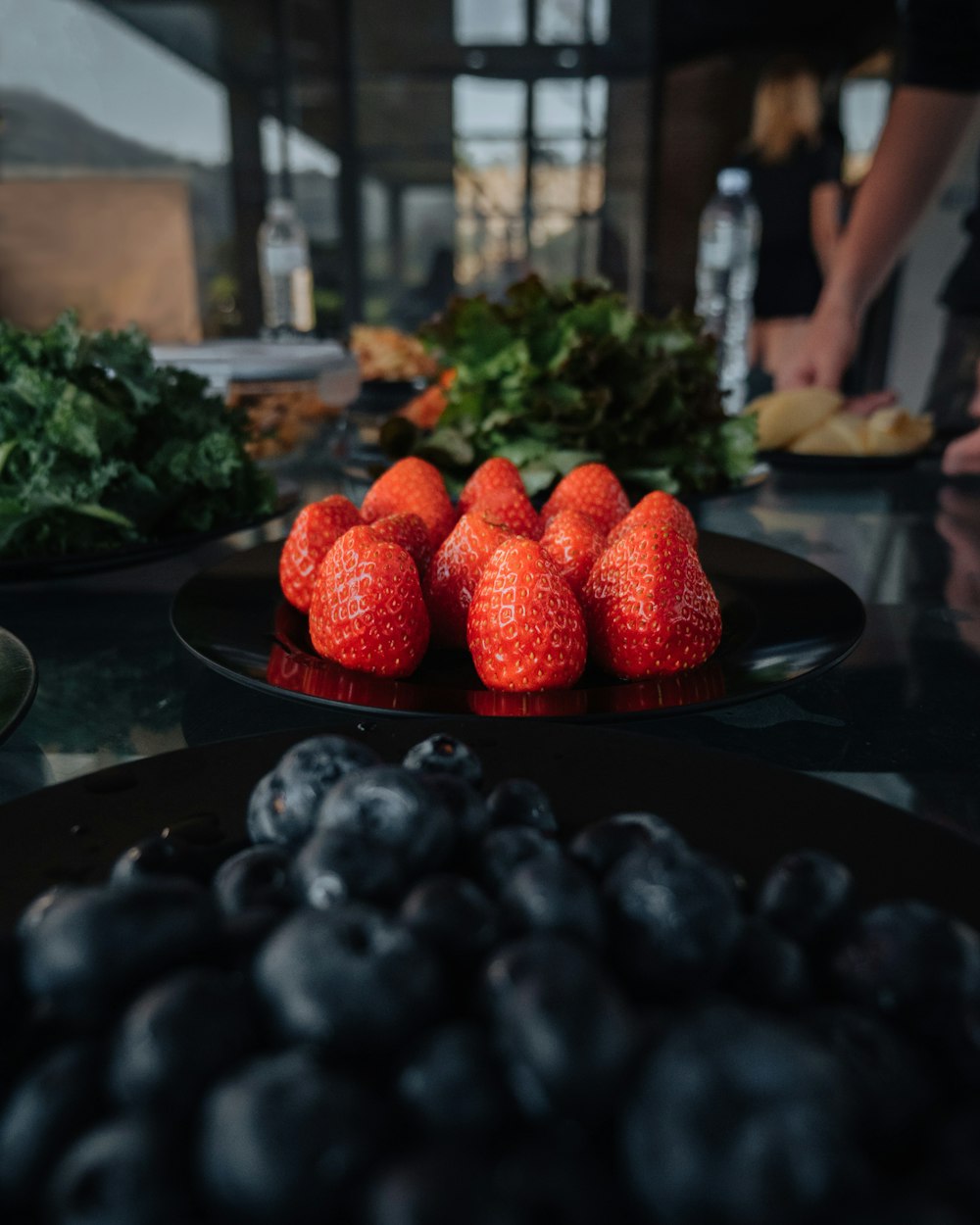 a plate of strawberries and blueberries on a table