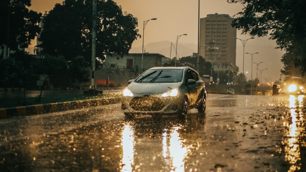 a car driving down a rain soaked street