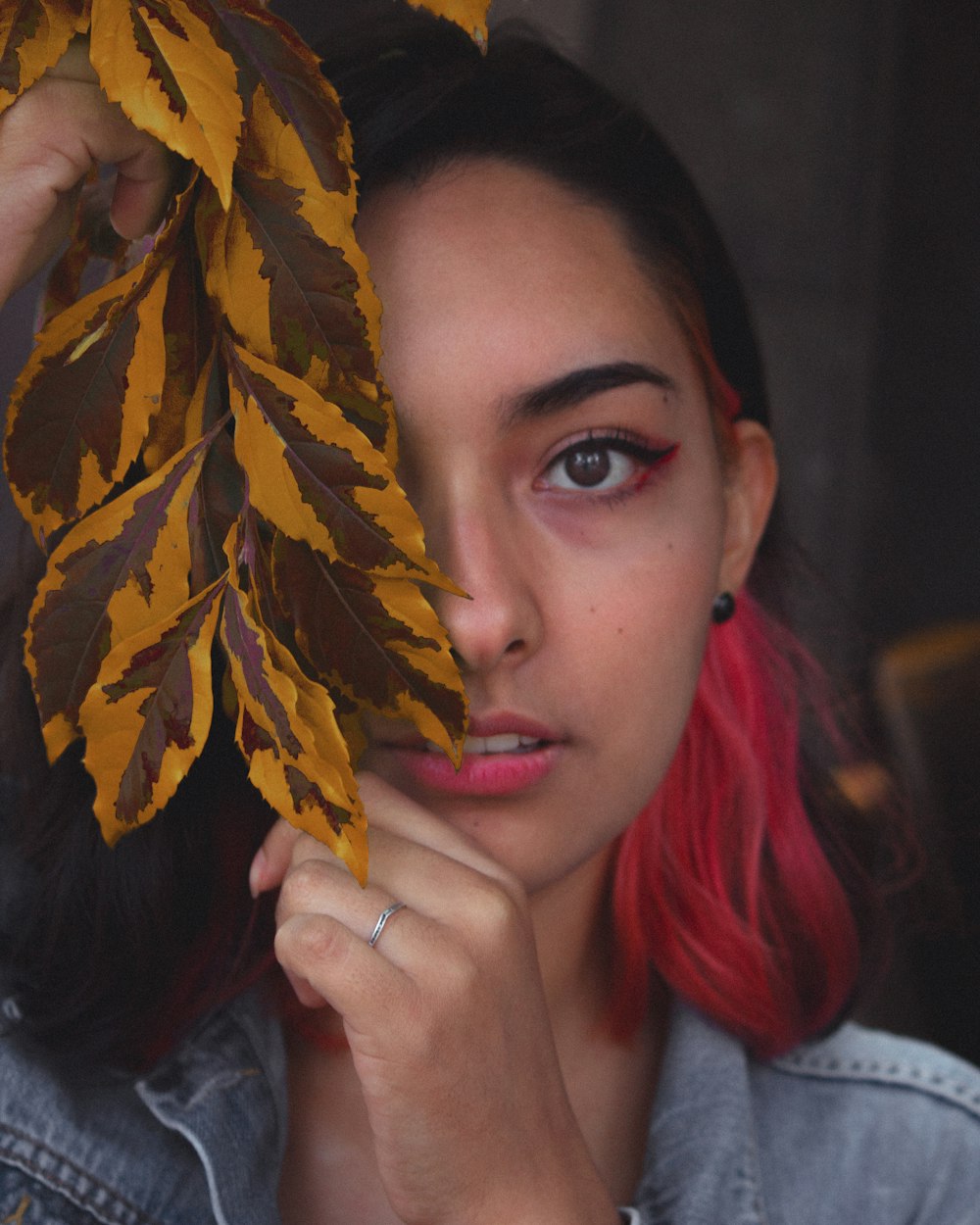 a woman with red hair holding a leaf