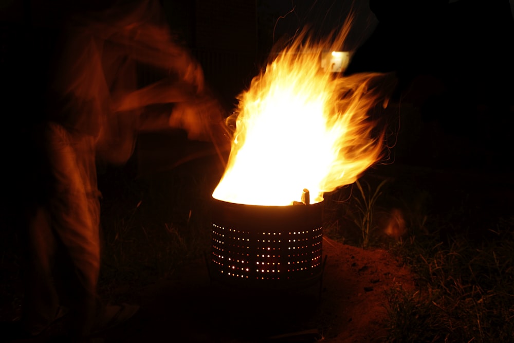 a fire pit is lit by a person in the dark