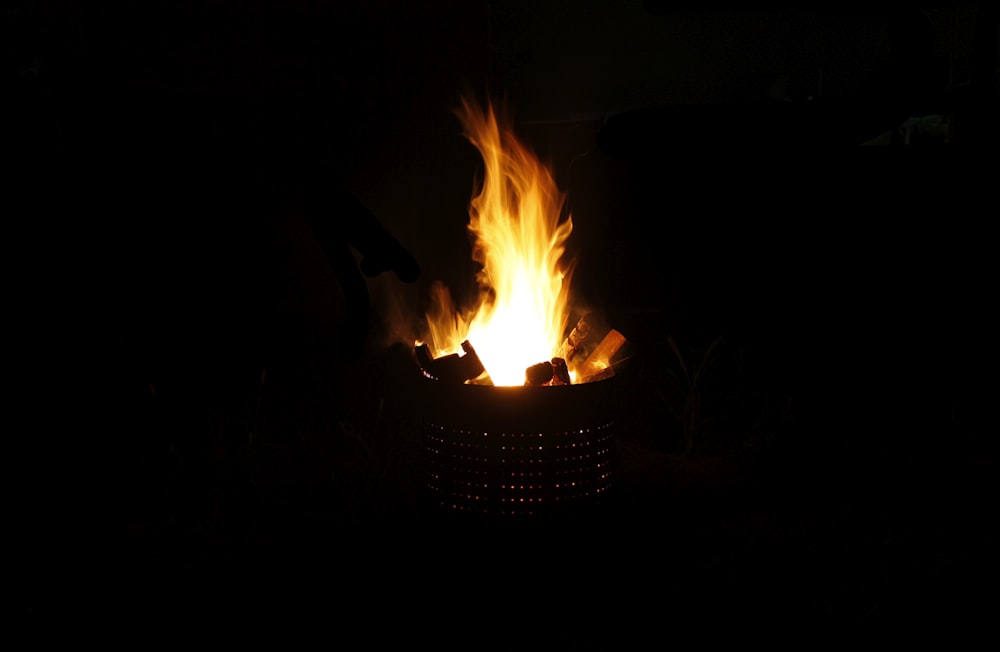a lit fire in the dark with a black background