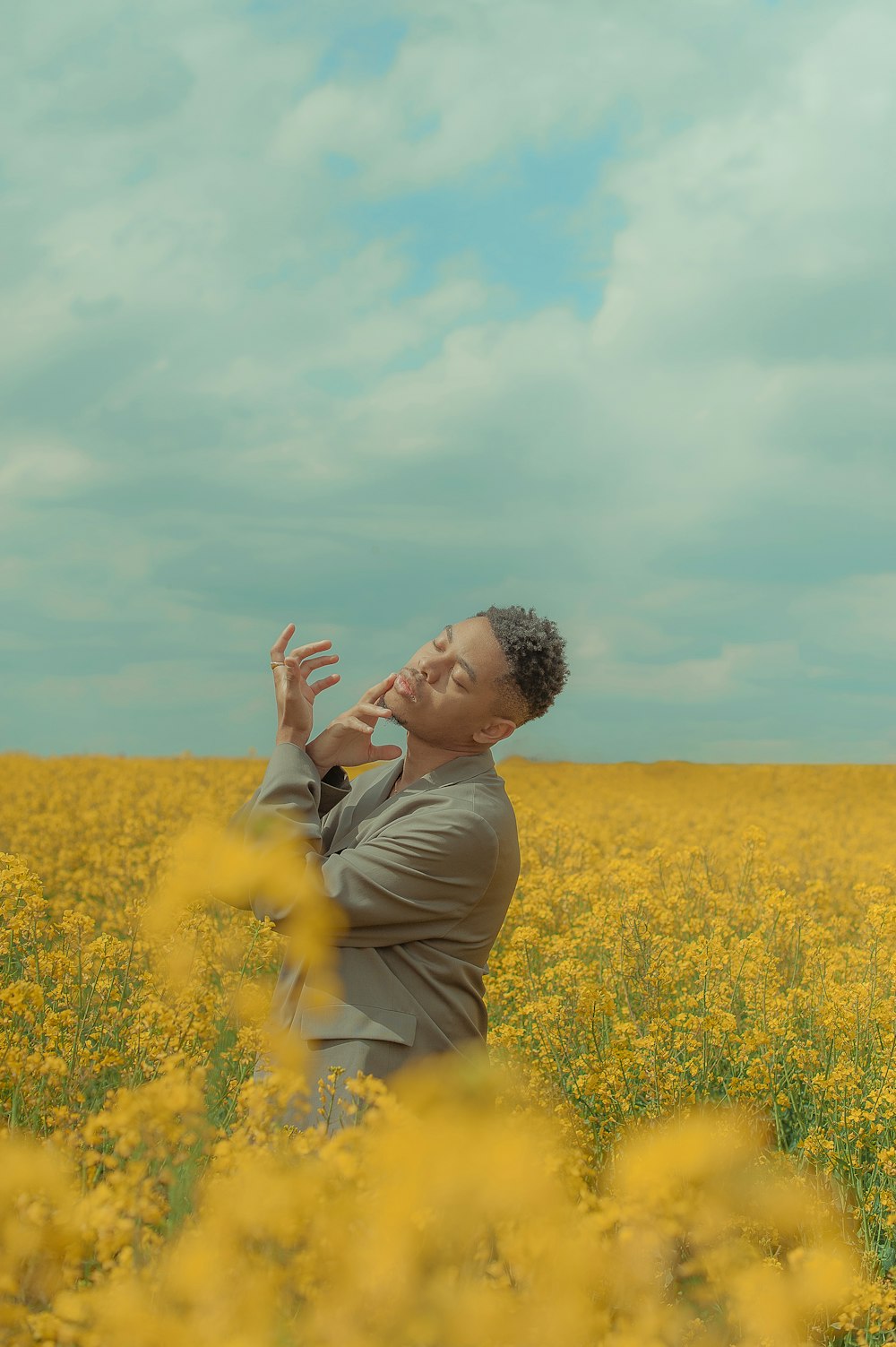 Un hombre parado en un campo de flores amarillas