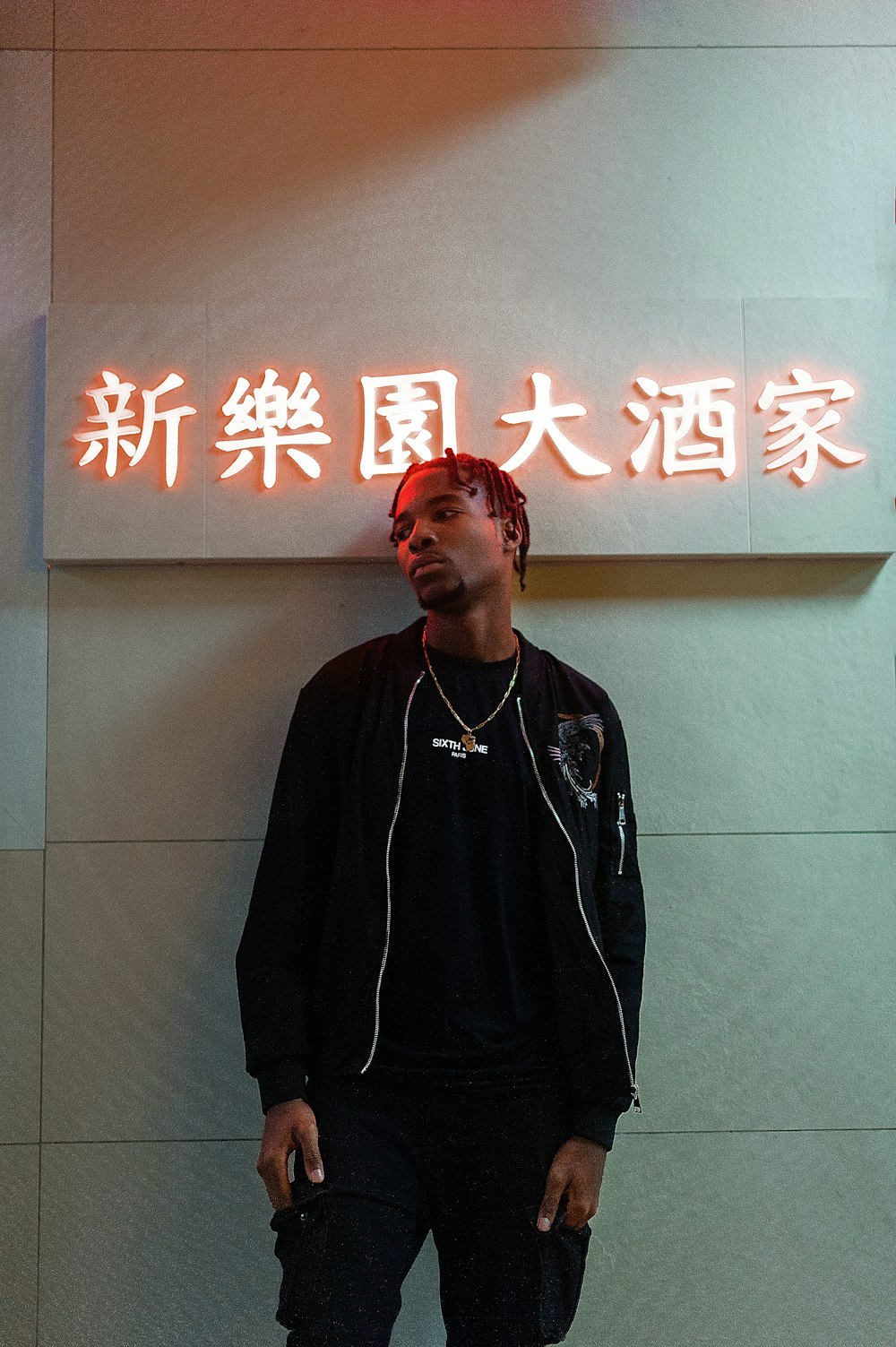 a man standing in front of a neon sign