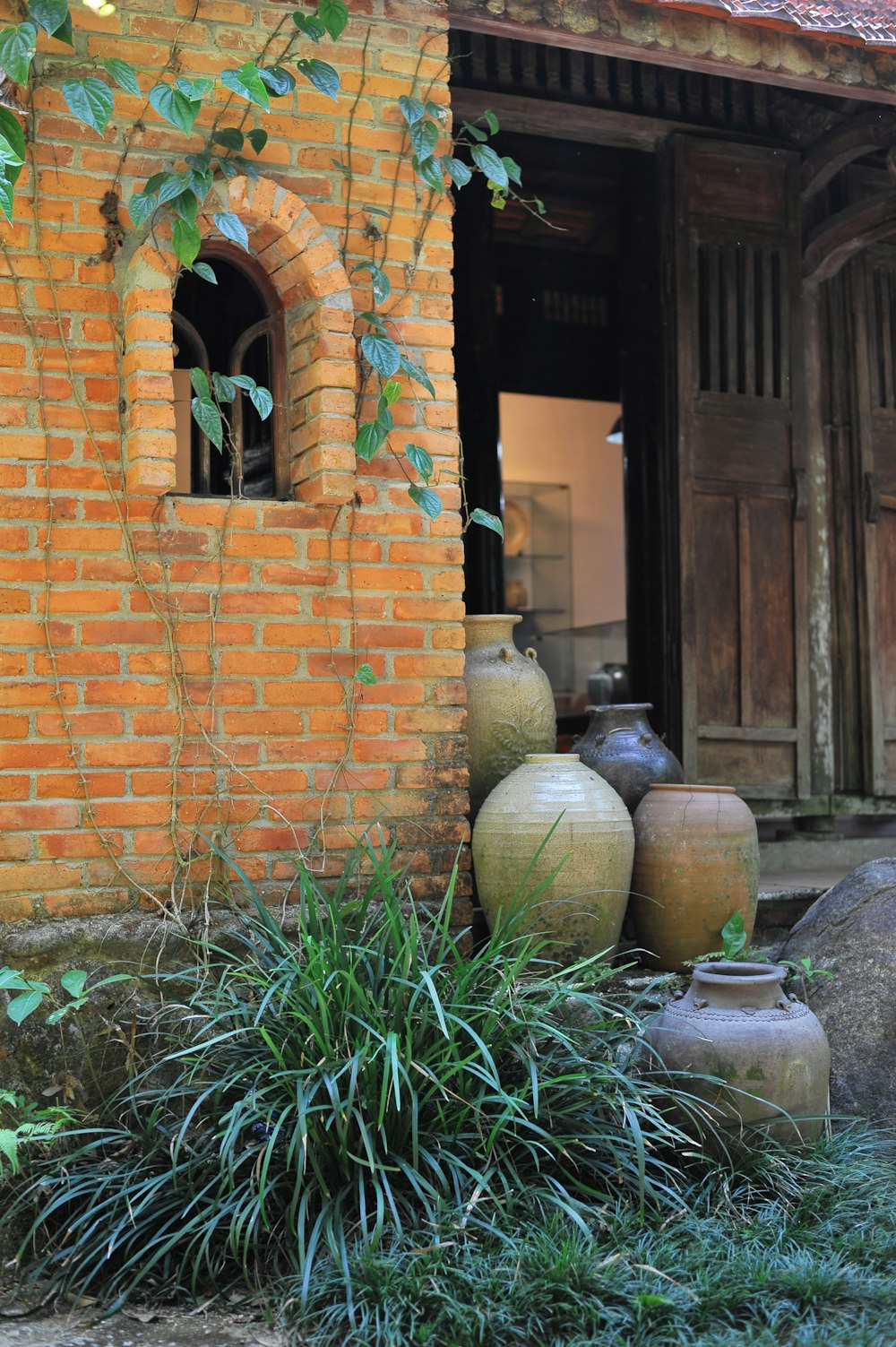 a group of vases sitting next to a brick building