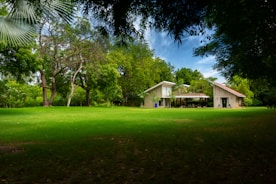 A beautiful exterior of a newly built house with a green lawn.