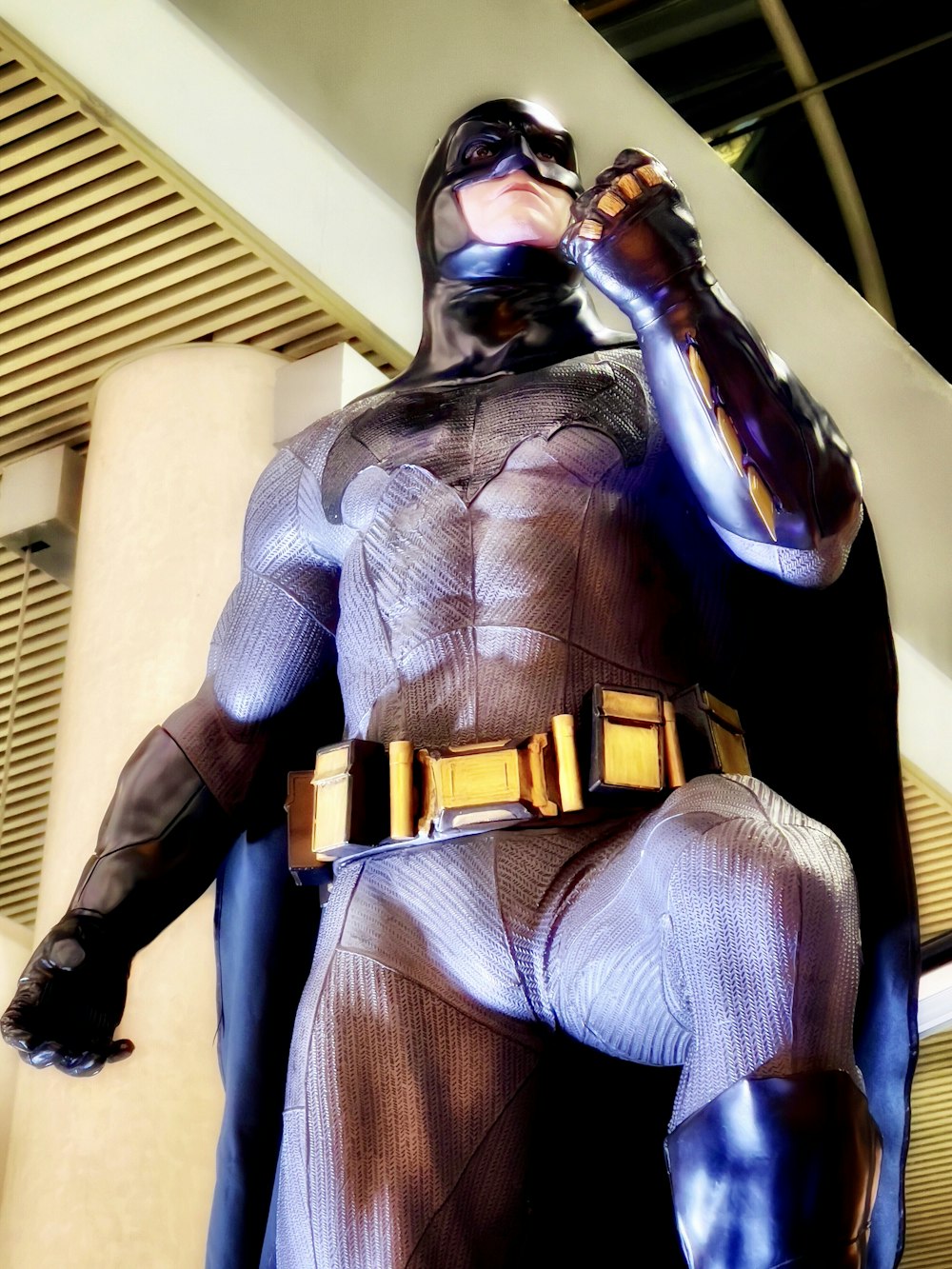 um homem em uma fantasia de batman bebendo de uma garrafa