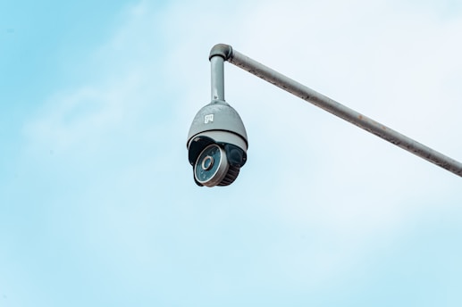 a camera attached to a pole with a sky background