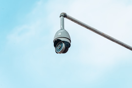 a camera attached to a pole with a sky background