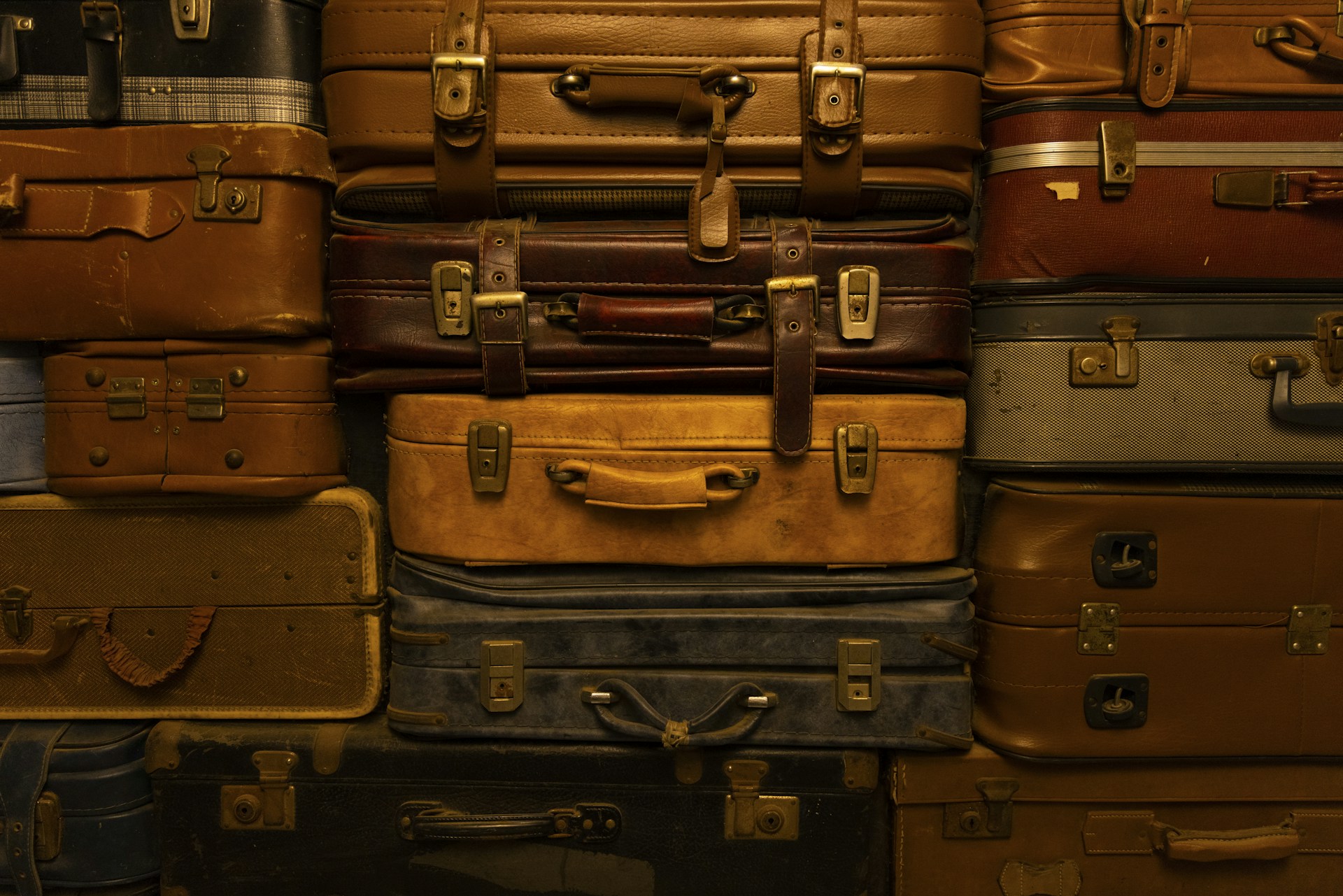 a pile of luggage stacked on top of a suitcase