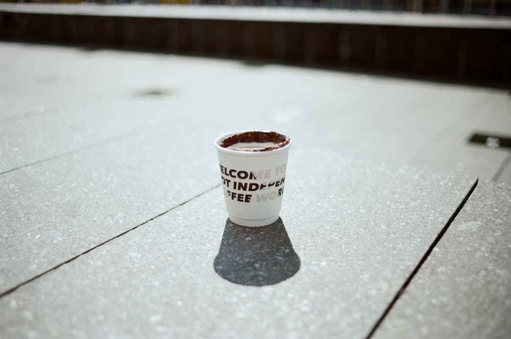 a cup of coffee sitting on the ground