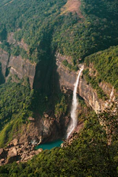 a waterfall in the middle of a lush green valley