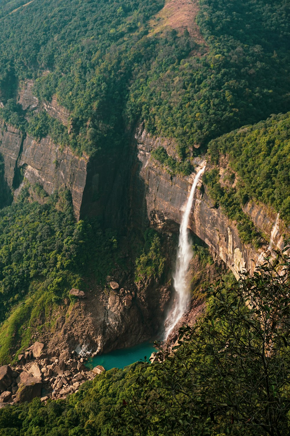 a waterfall in the middle of a lush green valley