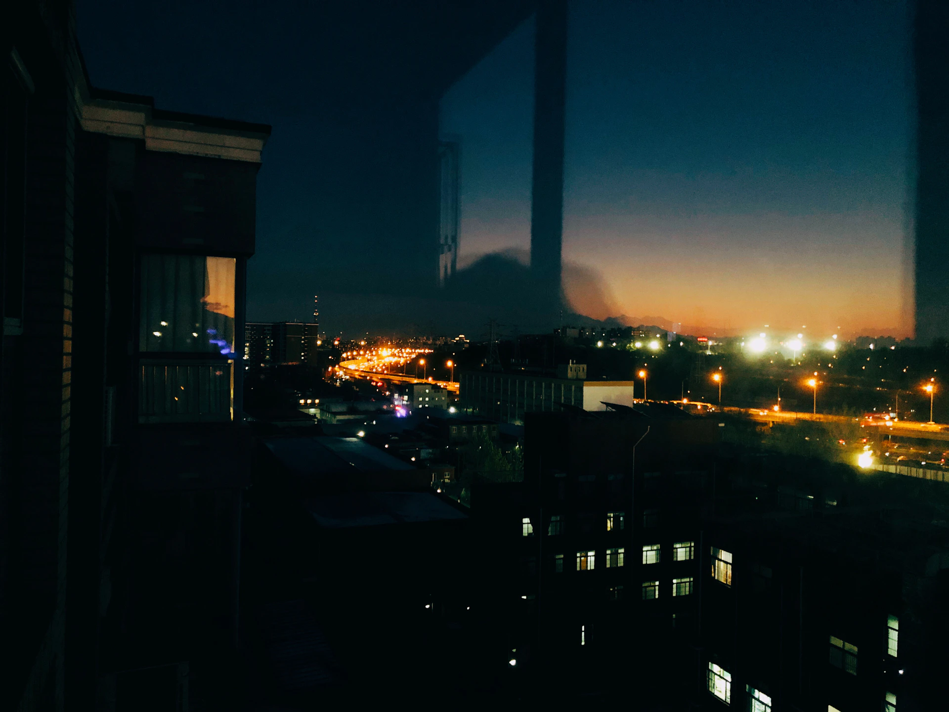 A striking large-format photograph capturing the delicate interplay of light and shadow on an urban landscape at dusk.